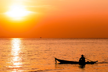 Fototapeta premium Silhouette of fishermen and his. sailing in the sea. Asian man o