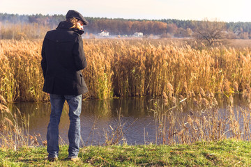 man standing near by the river, thinking about life and watching