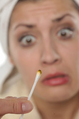 Shocked young woman with dirty cotton swab in her hand