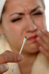 Disgusted young woman with dirty cotton swab in her hand
