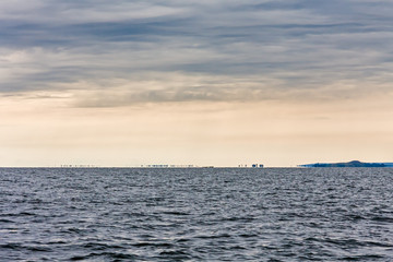 Panorama of Victoria Lake with distance view of hazy island optical illusion (mirage) in horizon against overcast morning sky background. Entebbe, Uganda, Eastern Africa.
