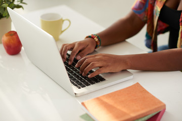 Fototapeta na wymiar Close-up image of woman typing on laptop