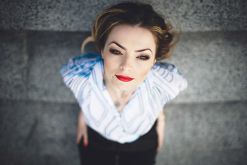 beautiful woman with red lips is looking at photographer