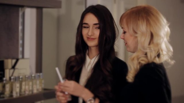 Consultant perfume shop offers the girl buyer the perfume 