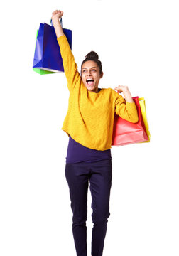 Excited young woman carrying shopping bags