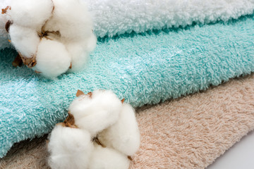 Fototapeta na wymiar Stack of bath towels with cotton blossom