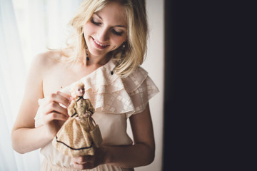charming girl with blond hair holding a beautiful doll