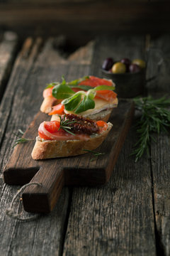 Bruschetta with smoked salmon, cheese, herbs and olives