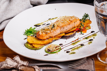 baked salmon with vegetables on glass plate isolated. Restaurant