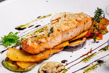 baked salmon with vegetables on glass plate isolated. Restaurant