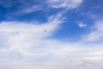 Orange boomerang flying in the sky