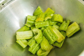Wash Vegetables - Bitter melon , Bitter gourd in steel basin
