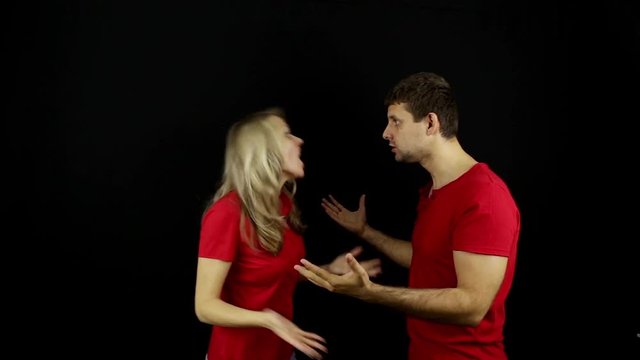 Man and woman swear. Family quarrel. Slap in the face. Young couple quarrel. Conflict. Dispute. Quarrel. Black background