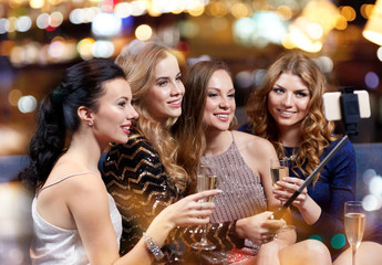 Obraz na płótnie Canvas women with smartphone taking selfie at night club