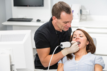 Dentist scanning patient's teeth with a CEREC scanner