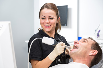 Dentist scanning patient's teeth with CEREC scanner