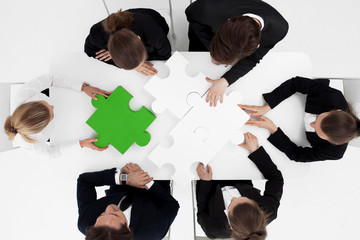 Business people assembling puzzle