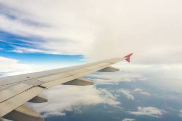 Fototapeta na wymiar Wing of airplane from window blue sky white cloud