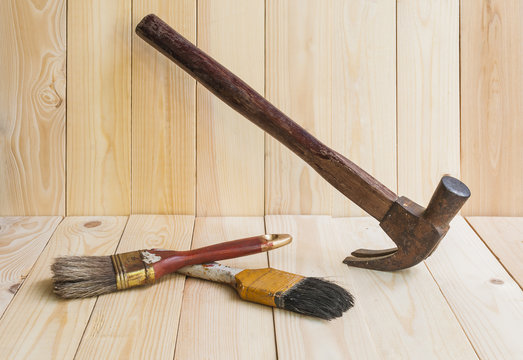 Tools, hammer and paint brush  on wood background