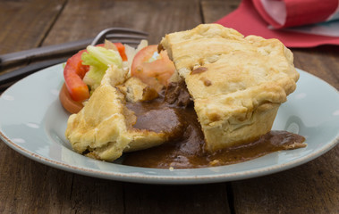 Steak pie and gravy on wood