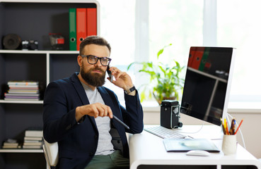 Obraz premium Handsome young man working from home office and using smartphone