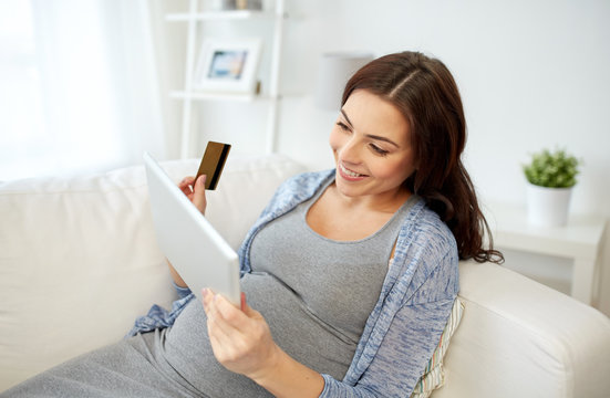 pregnant woman with tablet pc and credit card