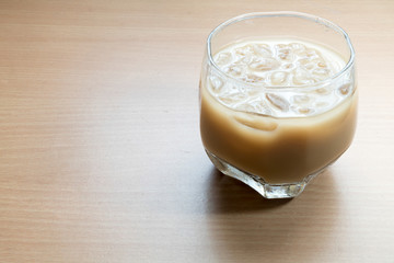 Ice coffee cup placed on a wooden table.