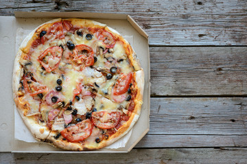 Tasty pizza and vegetables on a wooden table