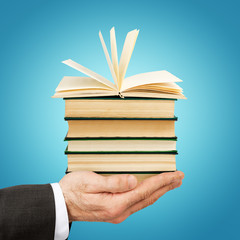 Business man holding stack of books
