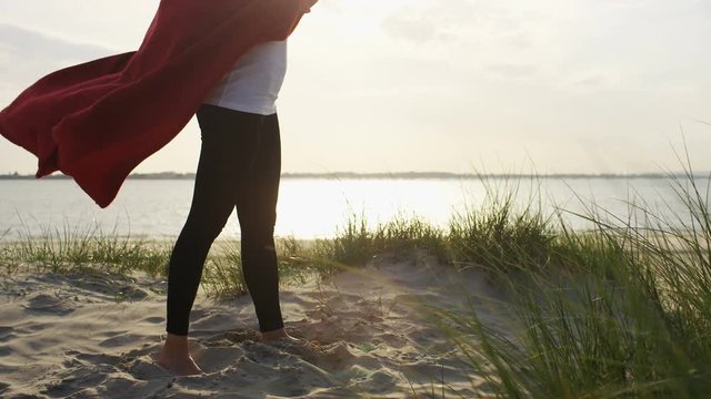 4K Young woman wears a blanket as a cape in the wind, in slow motion 