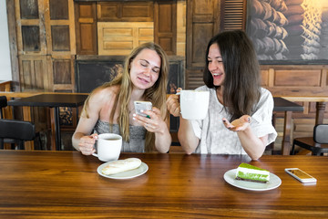 beautiful girls communicate in cafe and have coffee, tea, a meeting in cafe with a breakfast