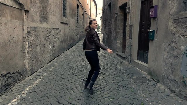 Afraid, scared woman running through street in the city,  super slow motion 
