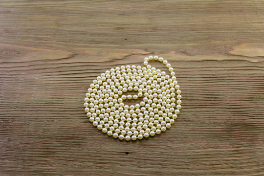 macro necklaces from the pearls twisted in a spiral on a wooden background