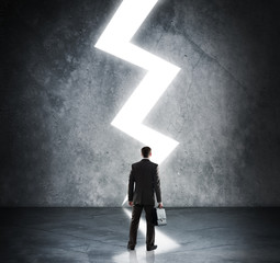 Businessman standing in light of lightning sign