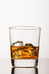 Whisky with ice on white background