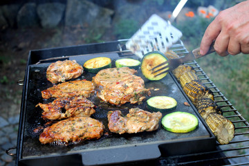 Grilling with barbecue stuff. Meat and vegetables on a stone slab.  - obrazy, fototapety, plakaty