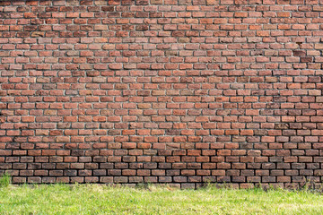 old red-orange brick wall and a lawn 2