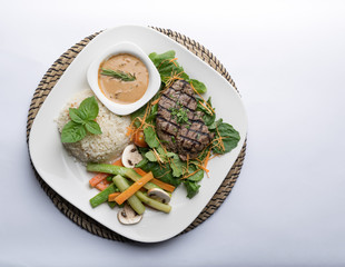 Beef filet steak served with rice, vegetables, and mushroom