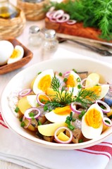 Salad of herring, boiled potatoes, eggs and onions with olive oil.