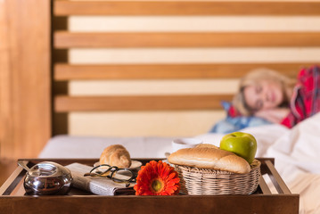 Sleeping woman and breakfast in bed