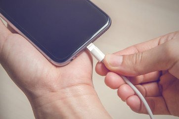 Close up hands holding phone charger