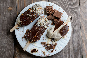 Chocolate popsicles on a brown wood background