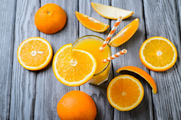 Composition with glass of orange juice and fruits on a wooden background. Selective focus, top view.