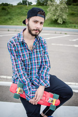 Stylish young guy on a red skateboard © ces