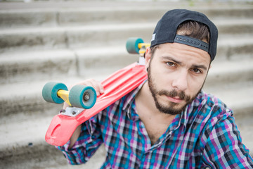 Stylish young guy on a red skateboard © ces