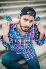Stylish young guy on a red skateboard © ces