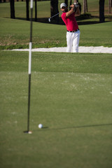 golfer hitting a sand bunker shot
