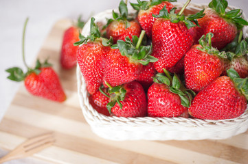 Stack strawberries in basket on wood floor