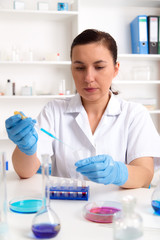 Scientist examining solution in petri dish at a laboratory
