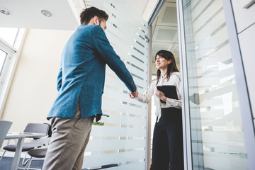Young businesswoman and client shaking hands in office